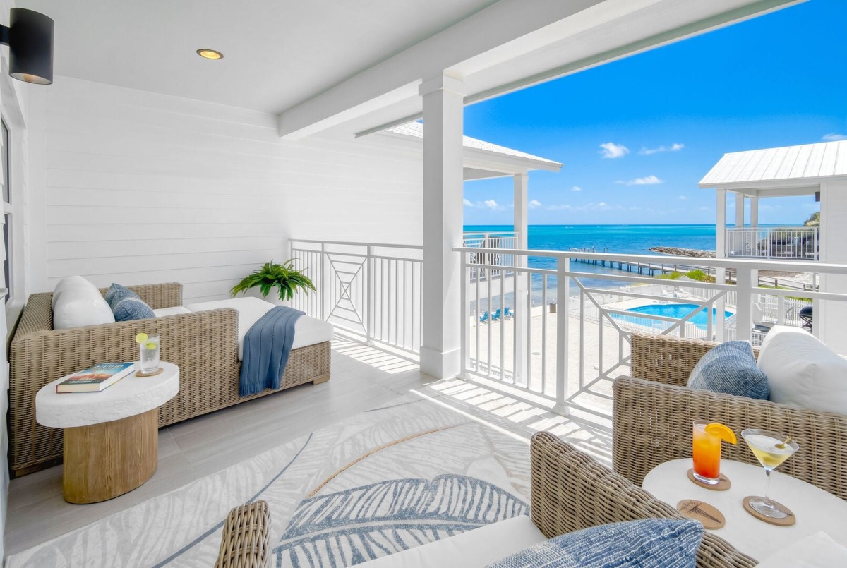 Primary bedroom private balcony offers ocean + pool view