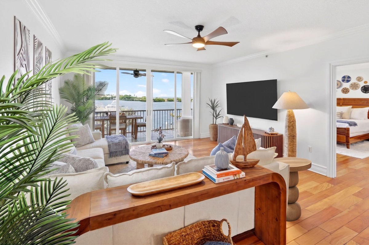 Open concept living room offers access to private, screened balcony with water view