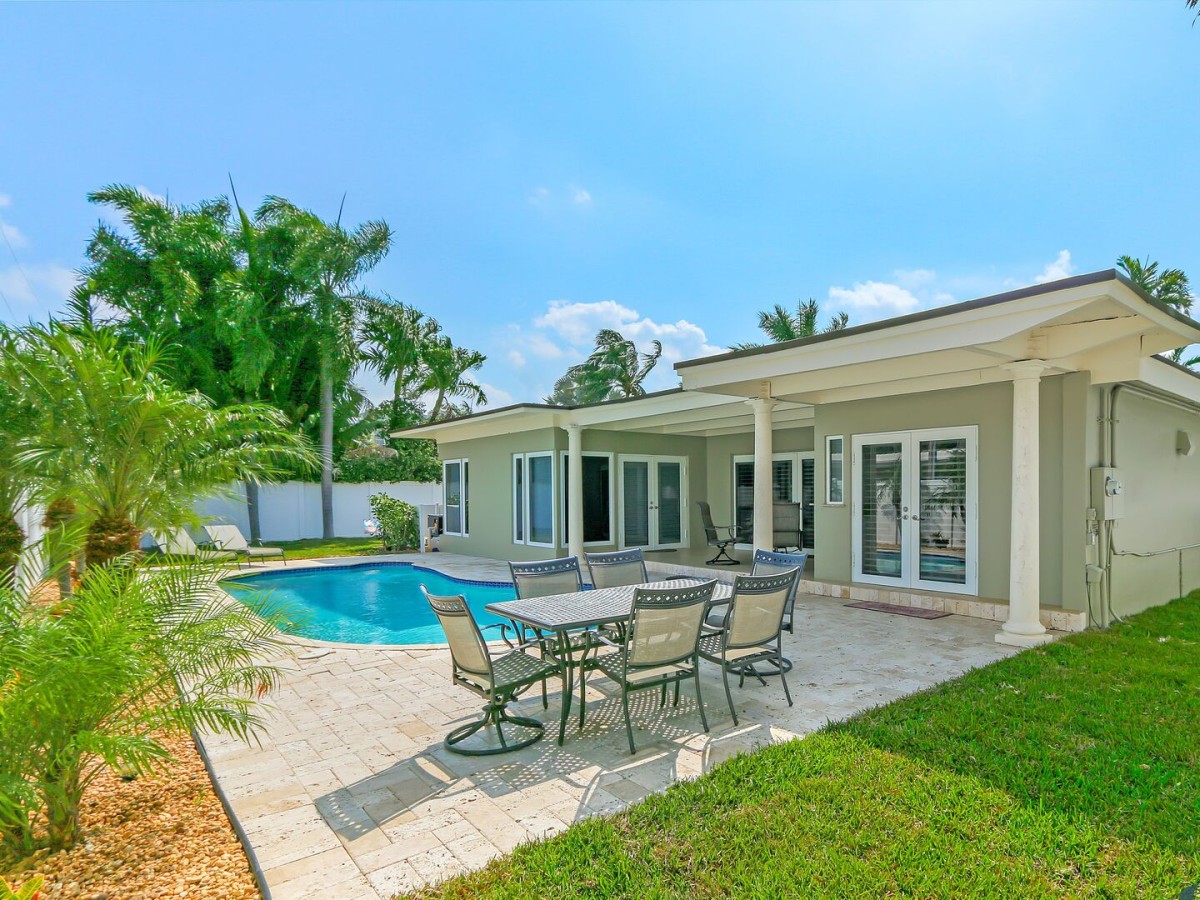 Private backyard offers a crystal blue swimming pool and seating area.